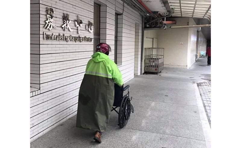 陳姓婦人昨雨衣、安全帽未脫，就急著將新購的輪椅推進聖母醫院募款中心，暖心舉動感動在場服務人員