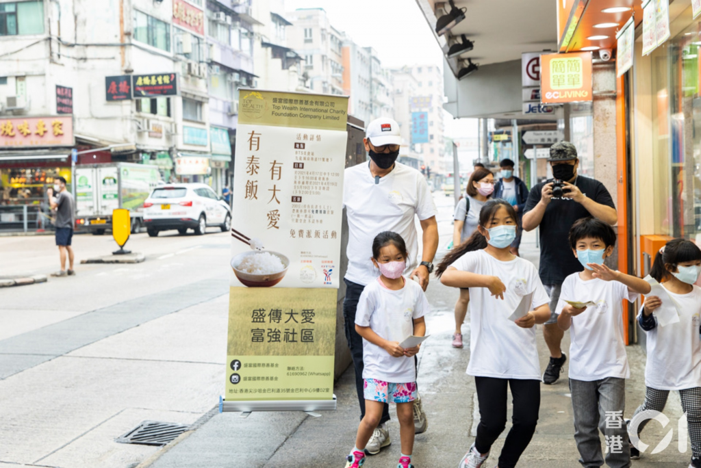 Jim與9歲大女橦橦，細女錡錡及兩位跟他學踩單車的小學員，準備出發派飯劵給長者。