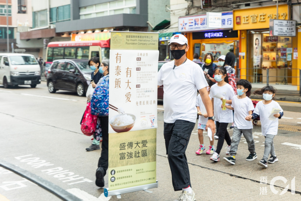 Jim與9歲大女橦橦，細女錡錡及兩位跟他學踩單車的小學員，準備出發派飯劵給長者。